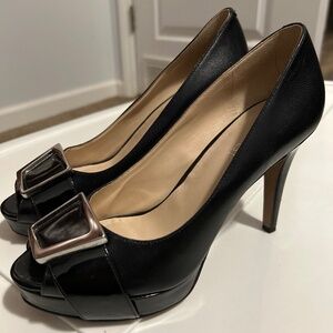 Nine West  black leather with black patten leather accents. Peep toe with silve.